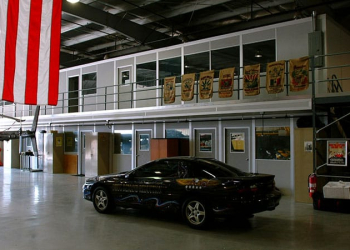 A two-story modular warehouse office and an American flag.
