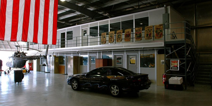 A two-story modular warehouse office and an American flag.