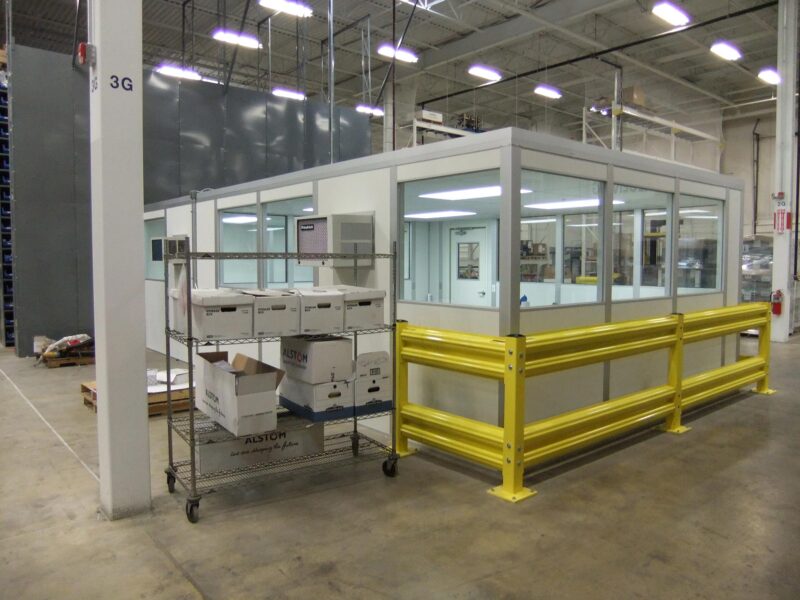 A modular in-plant office with a yellow guard rail.