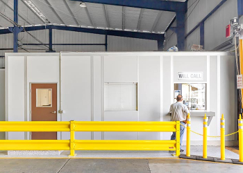 A modular in-plant office with a yellow guard rail.
