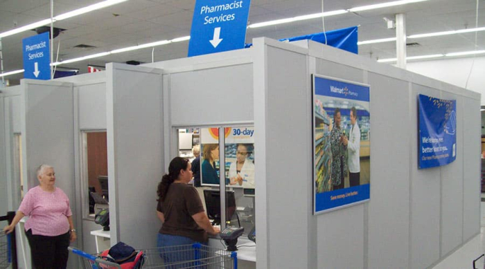 Modular pharmacy enclosure by Allied Modular inside a retail store, featuring service windows and private office space.