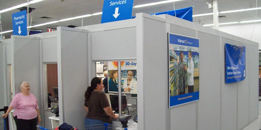 Modular pharmacy enclosure by Allied Modular inside a retail store, featuring service windows and private office space.