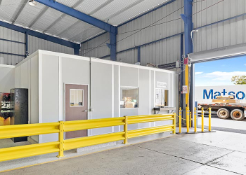 An in-plant modular office with a yellow guard rail.