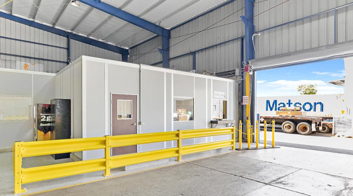 An in-plant modular office with a yellow guard rail.
