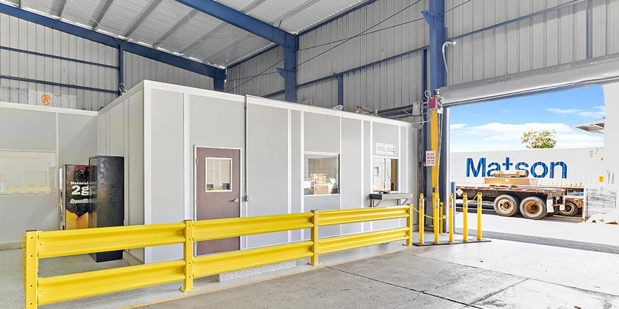 An in-plant modular office with a yellow guard rail.