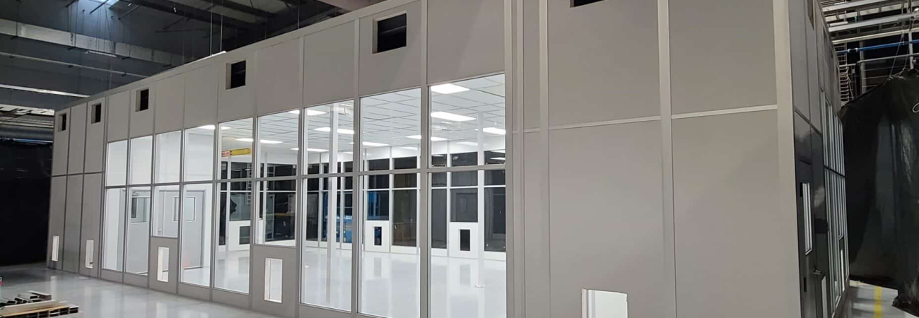 A tall walled modular enclosure within an existing warehouse.