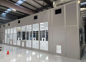 A tall walled modular enclosure within an existing warehouse.