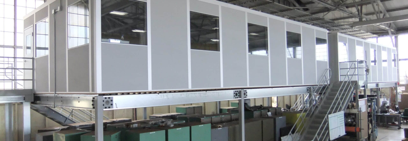 A gray modular office on top of a freestanding mezzanine.