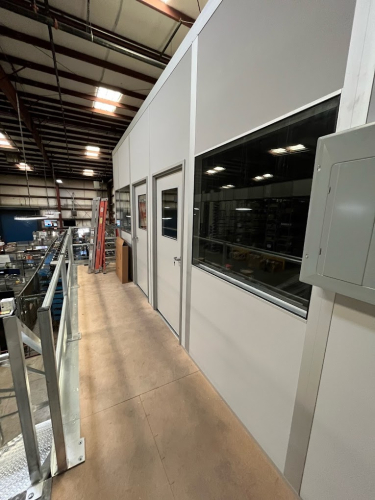 An office on a mezzanine within a warehouse environment.