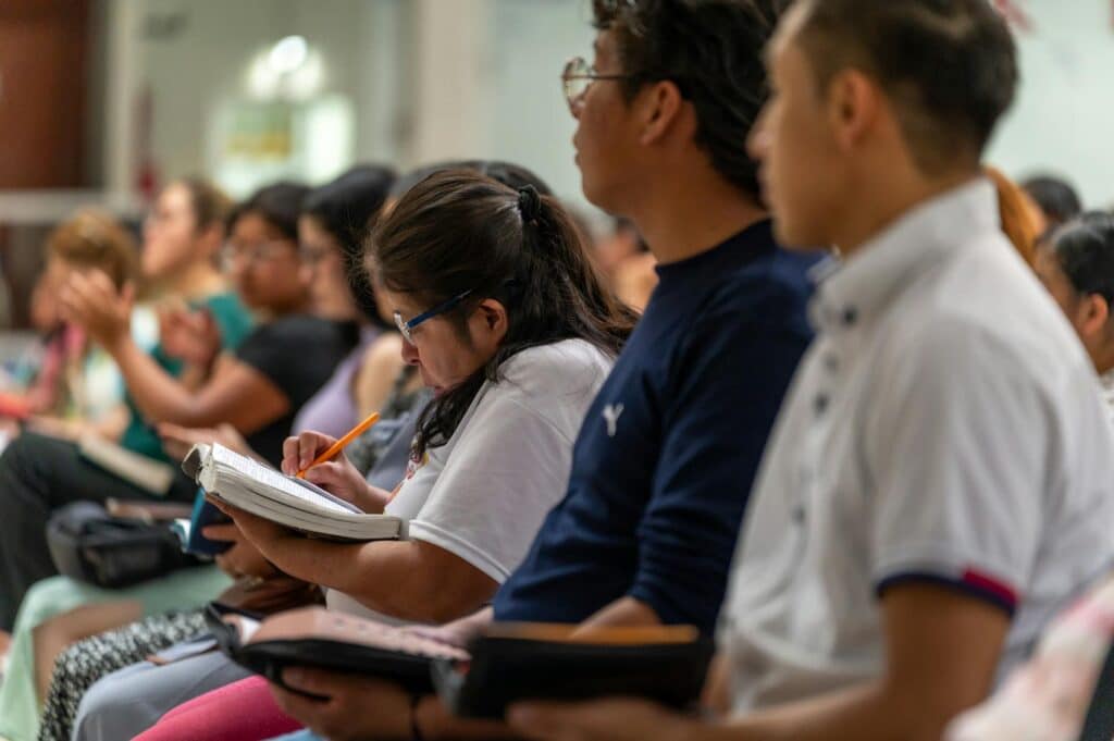 A large classroom full of students taking notes.