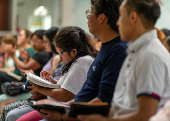 A large classroom full of students taking notes.