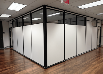 A modular office space with white partitions and glass panels.