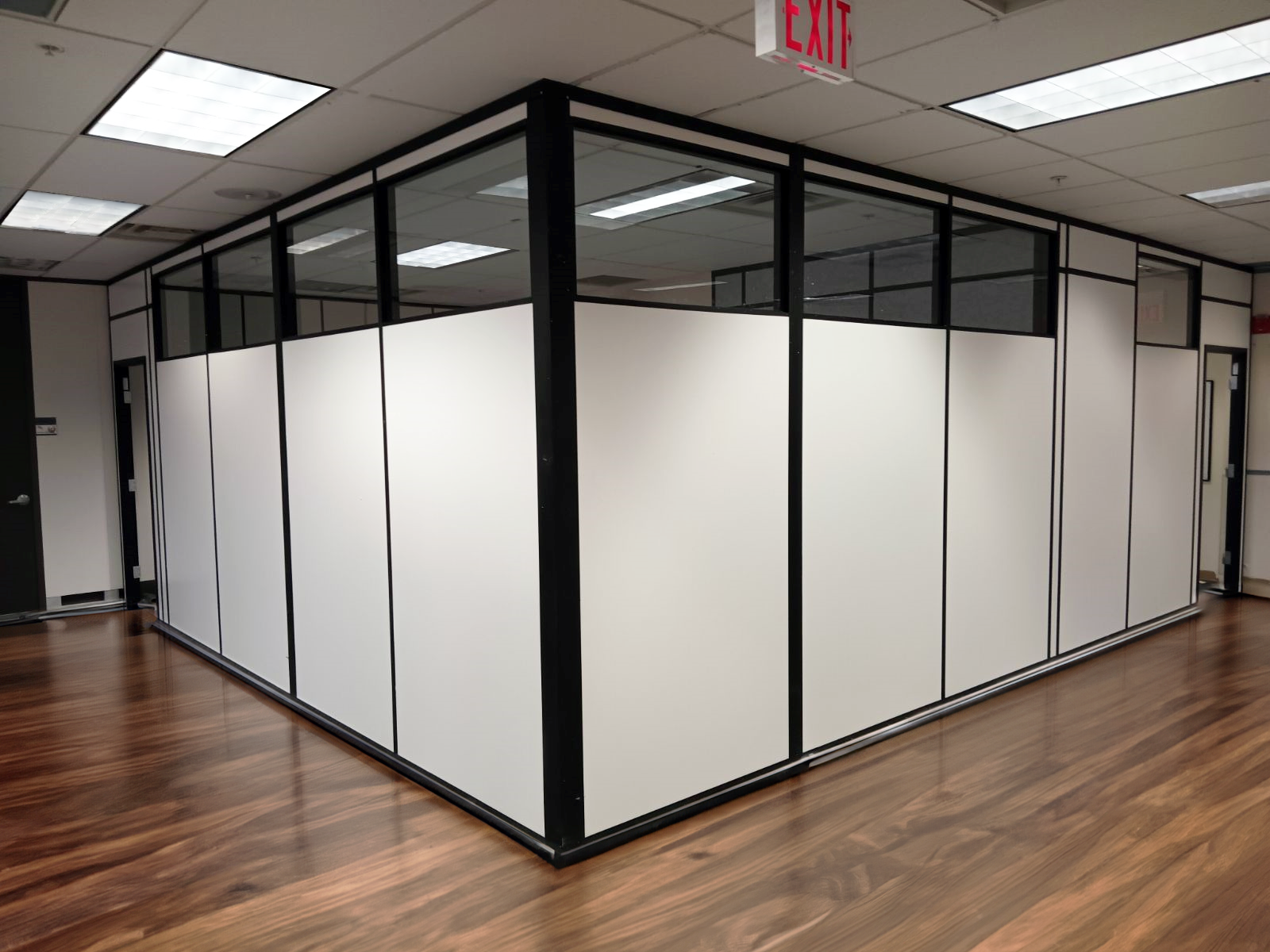 A modular office space with white partitions and glass panels.