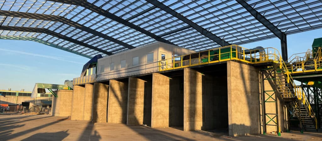 A warehouse with an elevated catwalk featuring yellow railings and stairs, providing access to different areas of the facility.