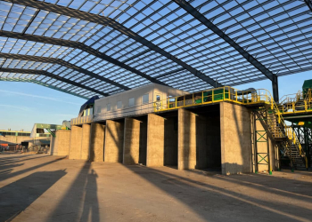 A warehouse with an elevated catwalk featuring yellow railings and stairs, providing access to different areas of the facility.