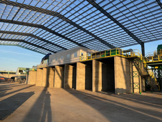 A warehouse with an elevated catwalk featuring yellow railings and stairs, providing access to different areas of the facility.