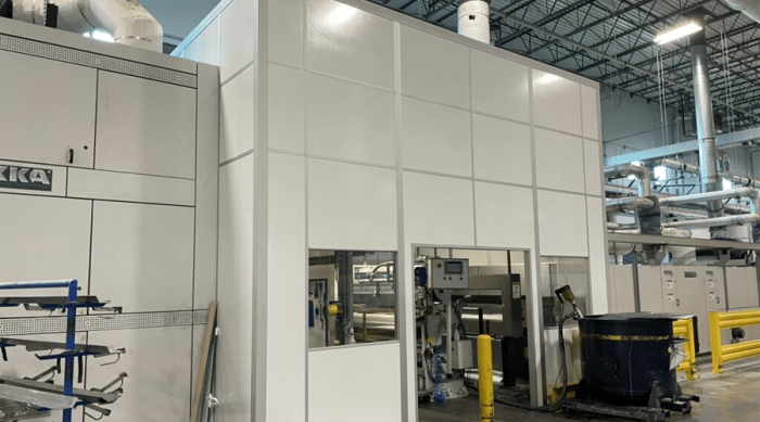 A large modular machine enclosure in a warehouse, designed to isolate machinery and reduce noise and emissions 1