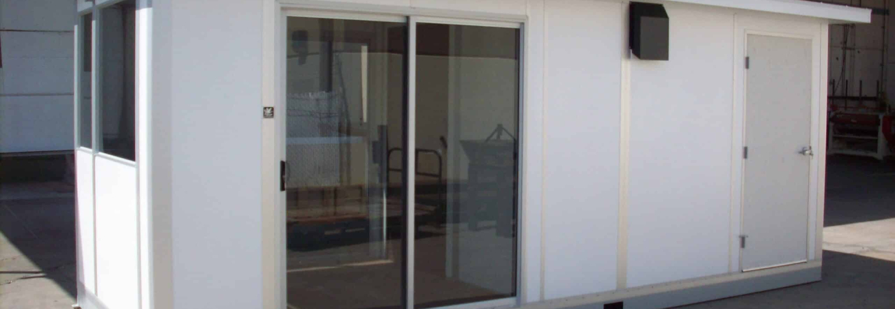 A modular scale house with sliding glass doors and a white exterior, designed to accommodate staff and equipment for managing weighbridge operations at industrial sites.