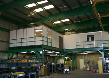 A modular mezzanine (catwalk) structure with safety railings in an industrial setting, designed to manage live loads effectively.