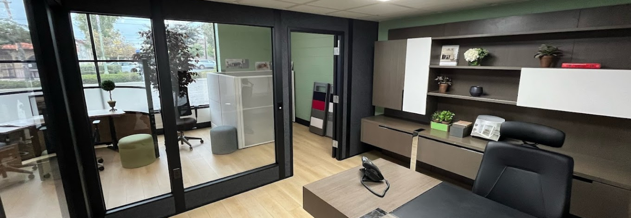 Modern office space featuring freestanding walls with full glass partitions, providing a clear division between the workspace and meeting area while maintaining an open, inviting atmosphere.