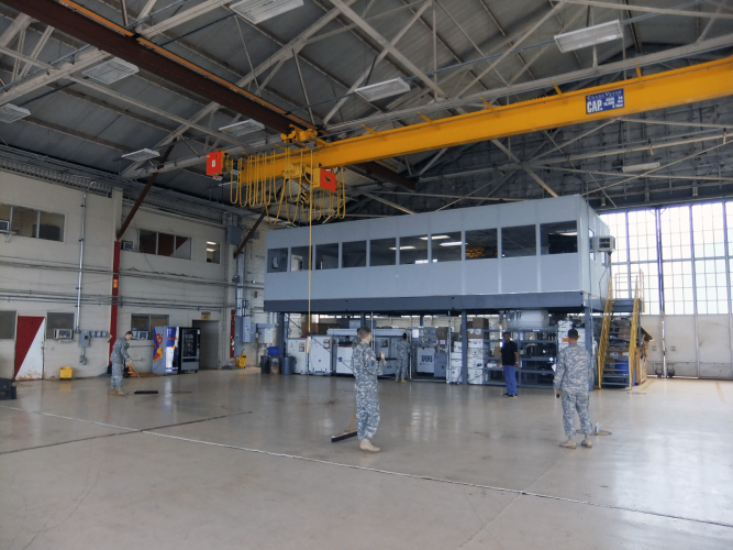 Allied Modular warehouse mezzanine with enclosed office space elevated above a production floor inside an industrial facility.