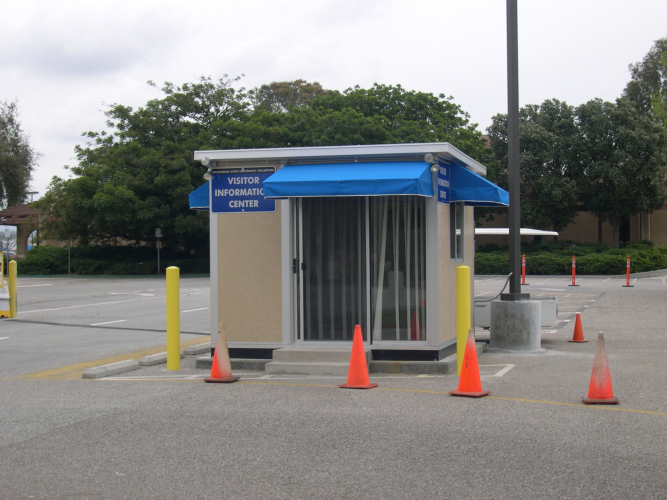 Custom guard shack with blue awning used as a visitor information center
