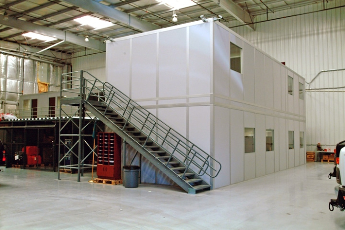 Two-story modular mezzanine office inside a warehouse by Allied Modular.