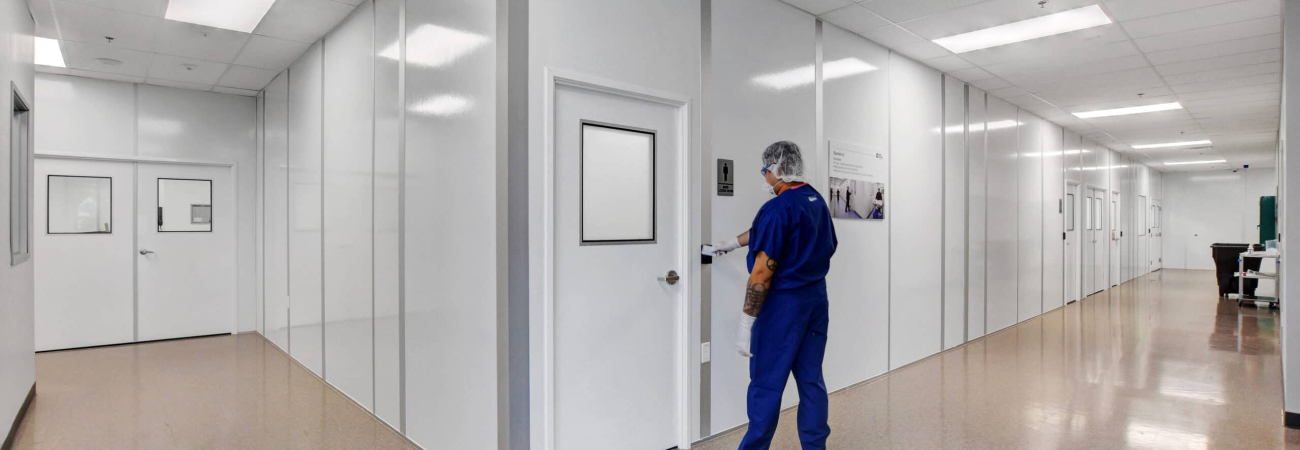 A technician entering one of Allied Modular’s controlled environment rooms designed for research and manufacturing applications.