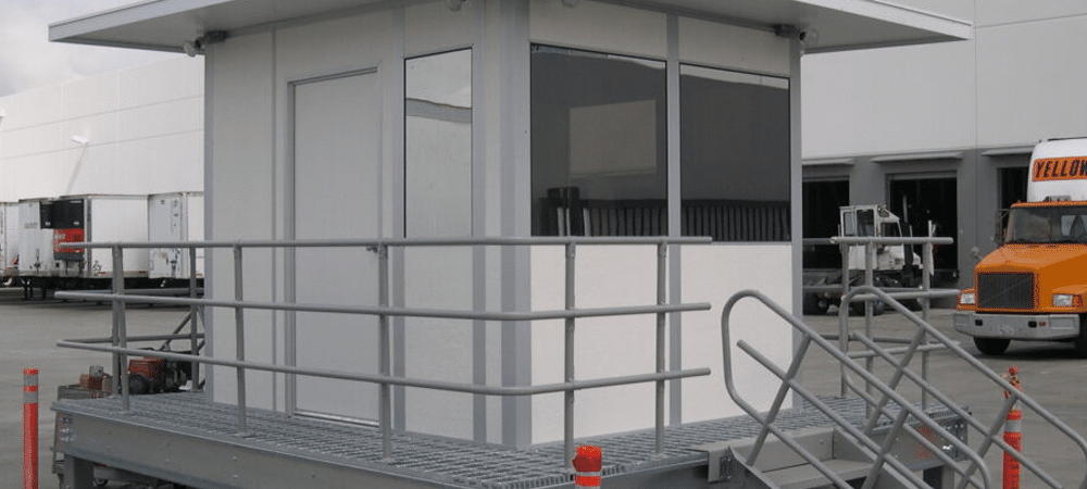Custom guard shacks by Allied Modular with elevated platform and metal stairs.