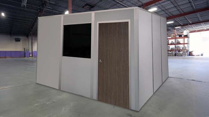 A modular office building by Allied Modular, installed inside a warehouse. The structure features a solid door, a window, and durable panel walls, providing a quick and efficient workspace solution.