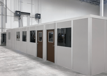 Modular inplant office installed in an industrial warehouse, featuring multiple doors, windows, and a clean, prefabricated design.