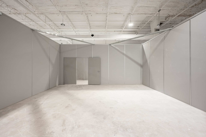 Allied Modular installation of a gray modular wall system inside a warehouse space with integrated door and clean interior finish.