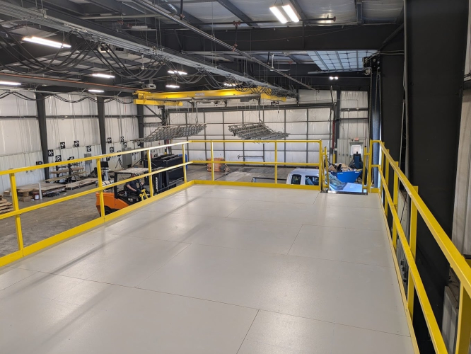 Mezzanine with yellow guardrails in a warehouse, showing how retail spaces can add extra storage or workspace.