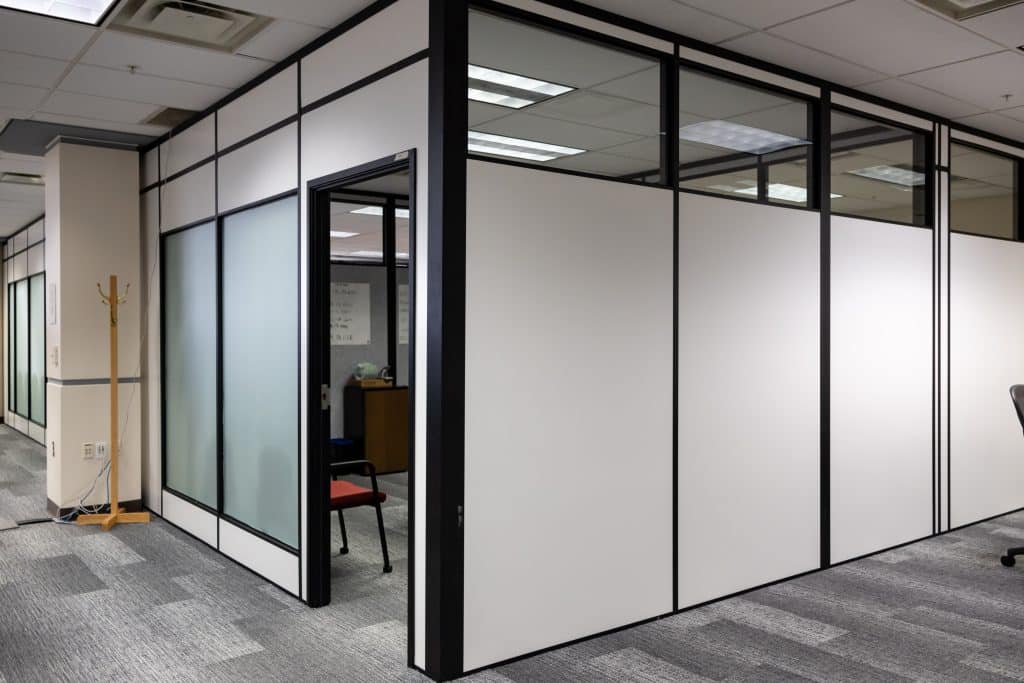 Modular office walls with black frames and white panels installed by Allied Modular inside a commercial office space