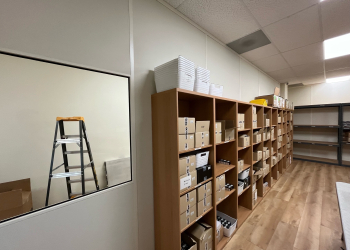 Allied Modular modular office partition walls separating a storage area with shelving units.
