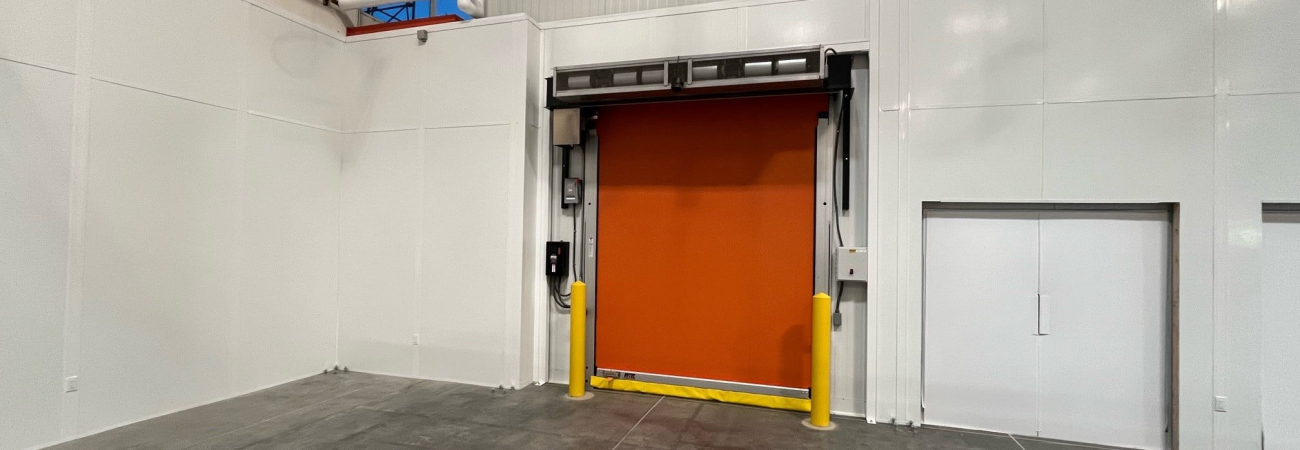 Allied Modular facility expansion construction showing modular wall panels and high-speed roll-up door inside a warehouse