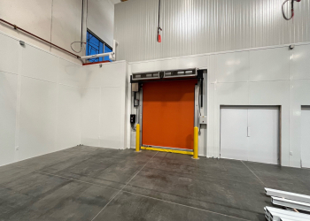 Allied Modular facility expansion construction showing modular wall panels and high-speed roll-up door inside a warehouse