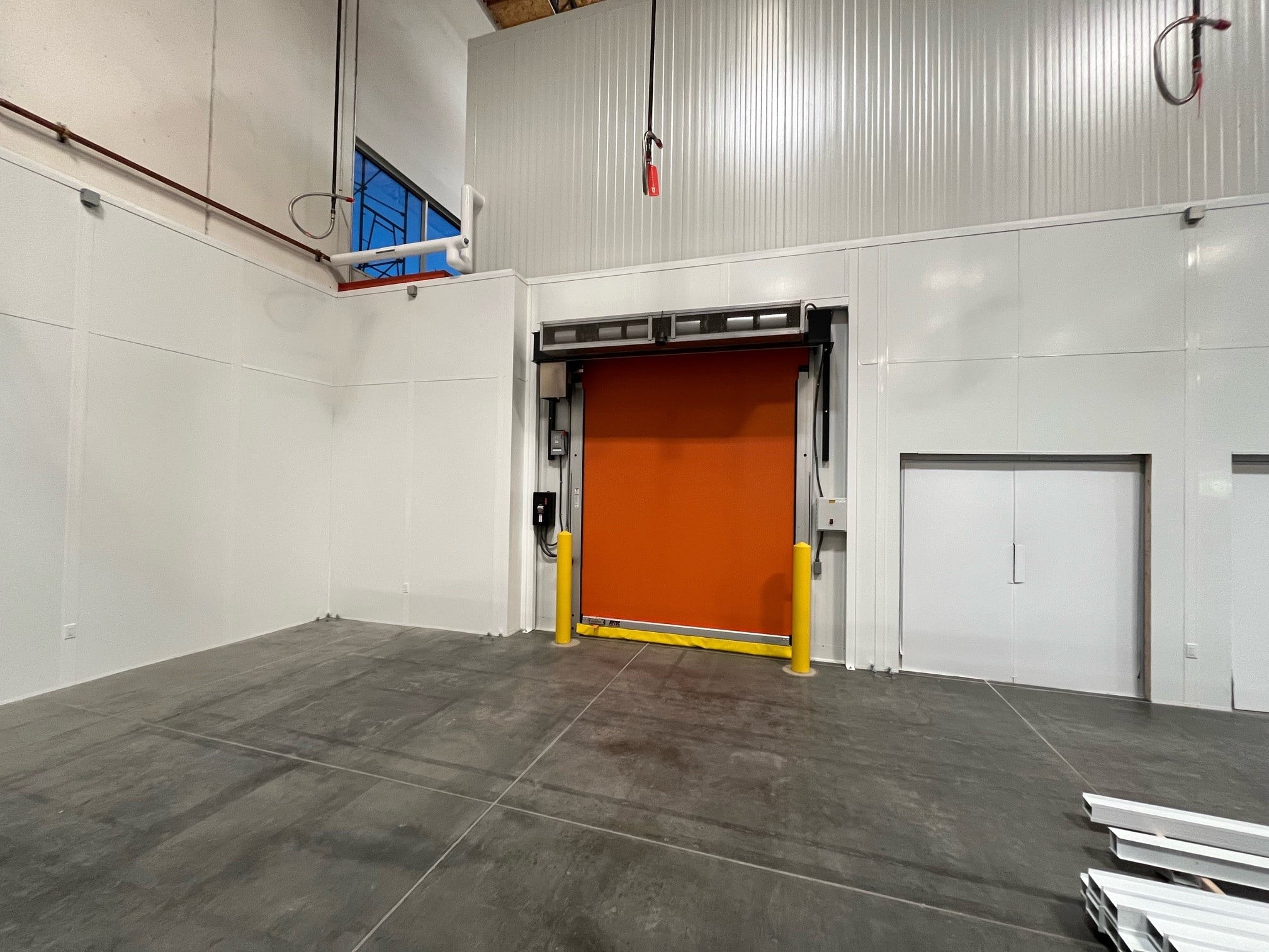 Allied Modular facility expansion construction showing modular wall panels and high-speed roll-up door inside a warehouse