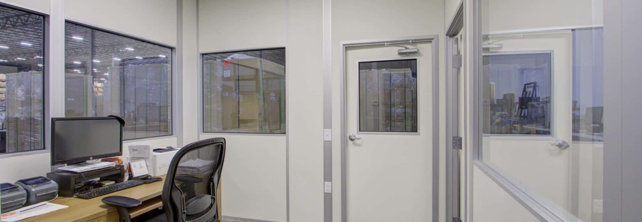 Interior of an office inside a modular building with glass windows and door.