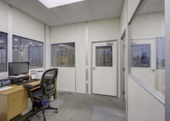 Interior of an office inside a modular building with glass windows and door.