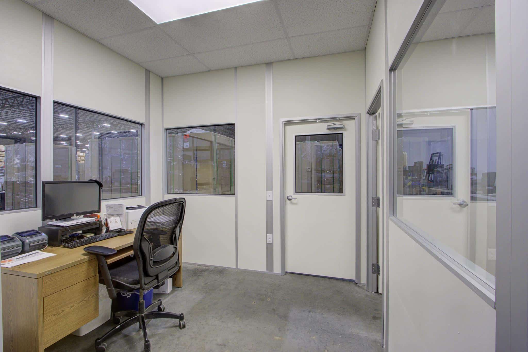 Interior of an office inside a modular building with glass windows and door.