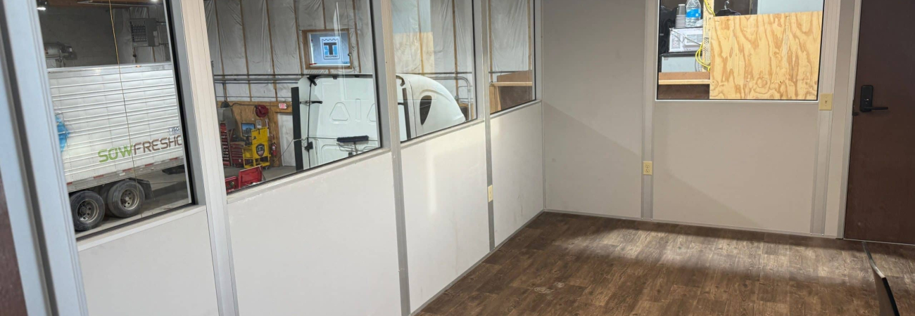 Interior view of Allied Modular warehouse mezzanine office, one of the many examples of modular construction, with windows and vinyl flooring.