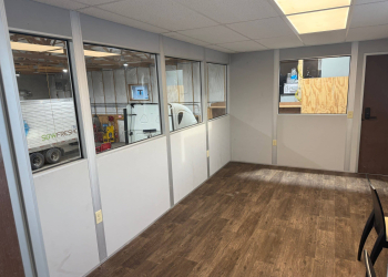 Interior view of Allied Modular warehouse mezzanine office, one of the many examples of modular construction, with windows and vinyl flooring.