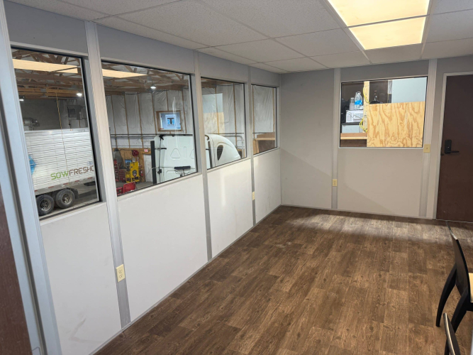 Interior view of Allied Modular warehouse mezzanine office, one of the many examples of modular construction, with windows and vinyl flooring.